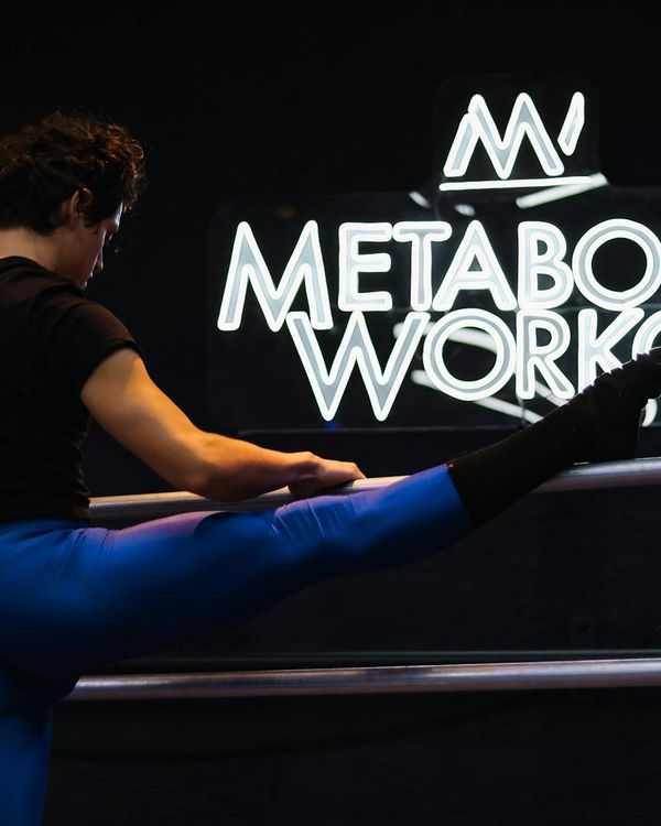Man performing a strength exercise in a modern, well-lit studio.